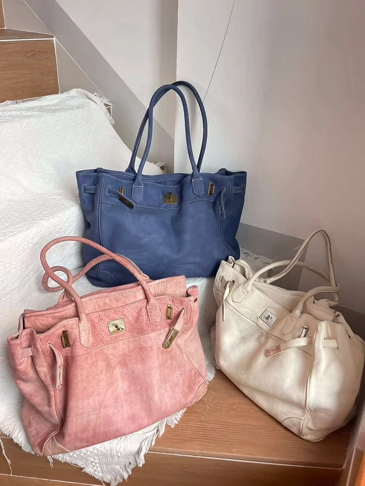 Blossom pink washed leather Firkin bag styled alongside navy blue and cream leather tote bags