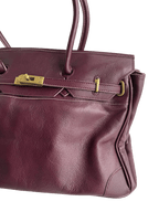 burgundy leather firkin bag side view with belt straps